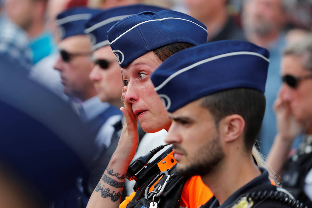 Policiais fazem um minuto de silêncio pelo colegas mortos em atentado (foto: Yves Herman/Reuters)