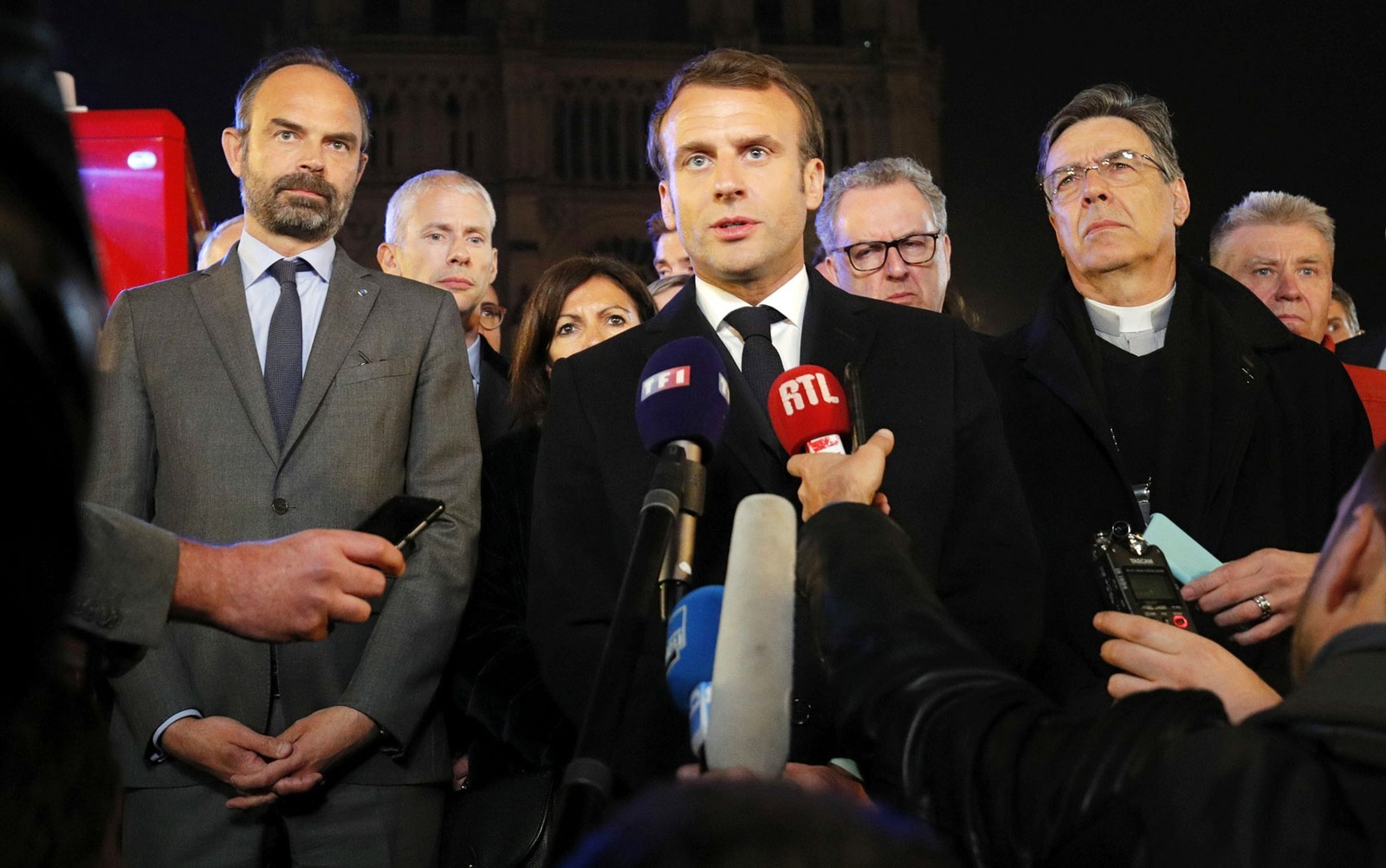 O presidente francês, Emmanuel Macron, ao lado do primeiro-ministro, Edouard Philippe, e do Arcebispo de Paris, Michel Aupetit, fala em frente à Catedral de Notre-Dame, em Paris, na segunda-feira (15) — Foto: Foto: Reuters/Philippe Wojazer/Pool