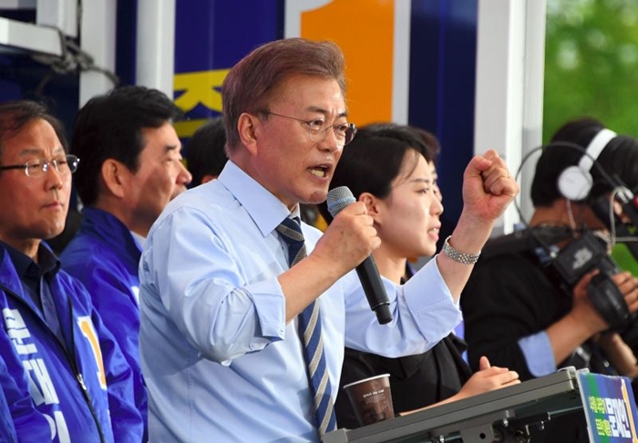 South Korean presidential candidate Moon Jae-In (C) of the Democratic Party speaks during his election campaign in Goyang city, northwest of Seoul, on May 4, 2017. South Korea will hold a presidential election on May 9 to replace former President Park Geun-hye, who was ousted from office in March over a corruption and abuse-of-power scandal. / AFP / JUNG Yeon-Je
