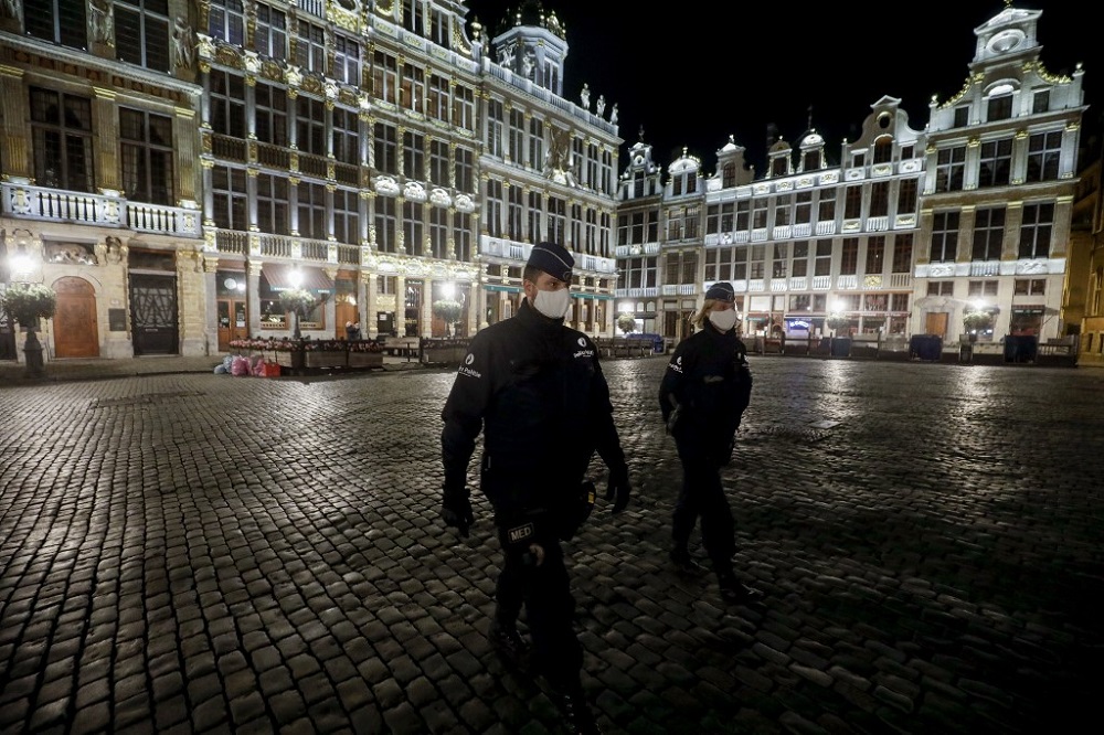 Police officers wearing protective face masks patrol at the start of the curfew in Brussels on October 19, 2020 as a measure against the spread of the COVID-19 pandemic caused by th novel coronavirus. - The consultative committee introduced stricter measures to reduce the risk of spreading COVID-19 as the contamination numbers are spiking. A curfew will be installed in the entire country from October 19, and no one will be allowed to leave their home between midnight and 5pm. (Photo by THIERRY ROGE / Belga / AFP) / Belgium OUT