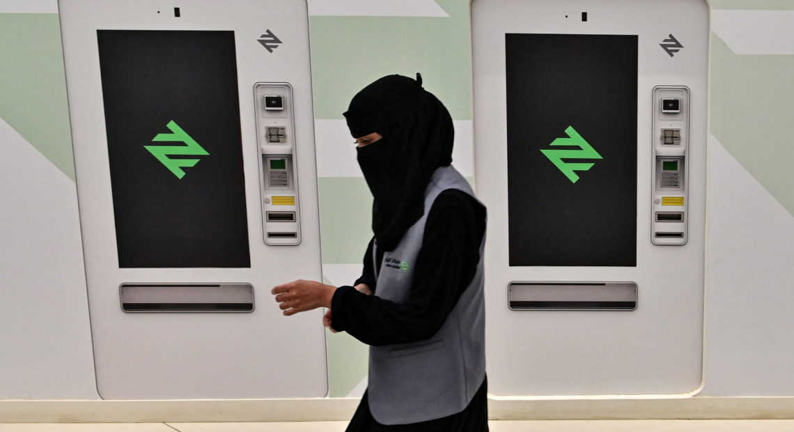 A woman employee of the Riyadh Metro walks past the new ticket issuing machines at a station, in the Saudi capital on December 9, 2019. - Saudi Arabia is boosting its infrastructure spending and expanding its railways -- including a $22.5 billion metro system under construction in the capital Riyadh -- as it seeks to diversify its oil-dependent economy. (Photo by GIUSEPPE CACACE / AFP)