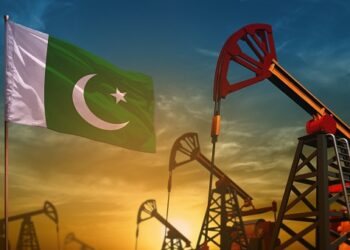 Pakistan oil industry concept, industrial illustration. Fluttering Pakistan flag and oil wells on the blue and yellow sunset sky background - 3D illustration