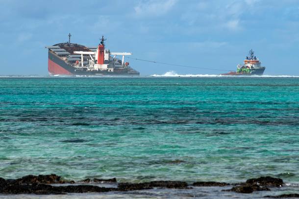 TOPSHOT - A picture taken on August 15, 2020 near Blue Bay Marine Park, shows the vessel MV Wakashio, belonging to a Japanese company but Panamanian-flagged, that ran aground near Blue Bay Marine Park off the coast of south-east Mauritius. - A fresh streak of oil spilled on August 14, 2020, from a ship stranded on a reef in pristine waters off Mauritius, threatening further ecological devastation as demands mount for answers as to why the vessel had come so close to shore. (Photo by Fabien Dubessay / AFP)