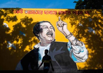 Homem passa por um mural representando o fundador de Bangladesh, Sheikh Mujibur Rahman, em Dhaka - Jewel Samad/AFP - AFP