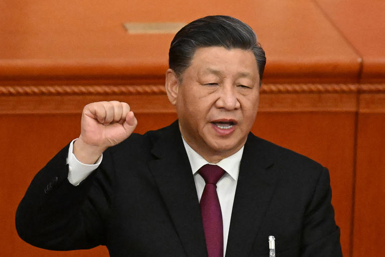 O presidente Xi Jinping ergue o punho e coloca a mão na Constituição da China no Grande Salão do Povo em Pequim Fotografia: Mark R Cristino/EPA