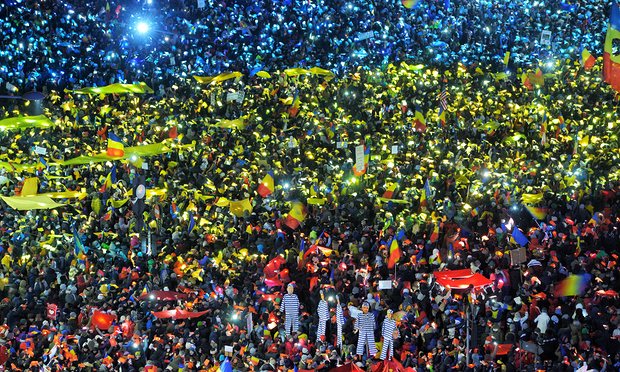 Thousands of protesters in Bucharest on Sunday created a huge flag using coloured paper in blue, yellow and red lit by their mobile phones. Photograph: Hepta/Barcroft