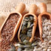 Flax, pumpkin and sunflower seeds in wooden spoons