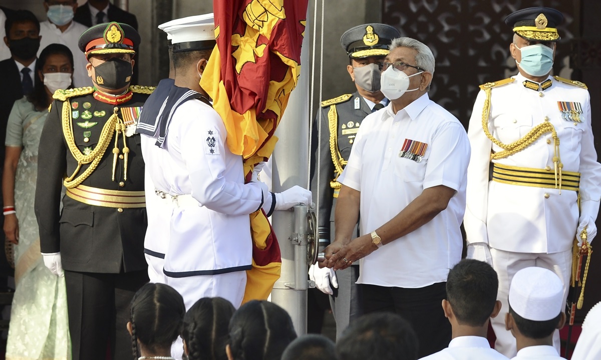 Sri Lanka's President Gotabaya Rajapaksa (2R) looks at a soldier raising a national flag during the Sri Lanka's 73rd Independence Day celebrations in Colombo on February 4, 2021. (Photo by LAKRUWAN WANNIARACHCHI / AFP)