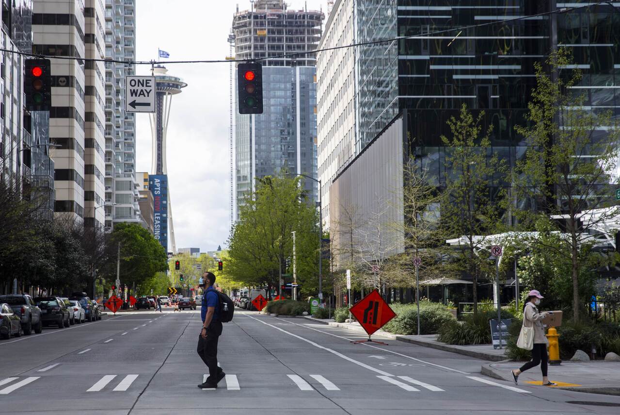 SEATTLE, WA - APRIL 30: People in masks cross the street, the Space Needle in the background, next to the downtown Amazon campus on April 30, 2020 in Seattle, Washington. Amazon recorded sales of $75.4 billion in the first three months of the year as many consumers increased their online purchases, up 26% over last year, but with net income for the same period falling nearly 31% due to costs of managing the coronavirus pandemic.   Lindsey Wasson/Getty Images/AFP
== FOR NEWSPAPERS, INTERNET, TELCOS & TELEVISION USE ONLY ==
