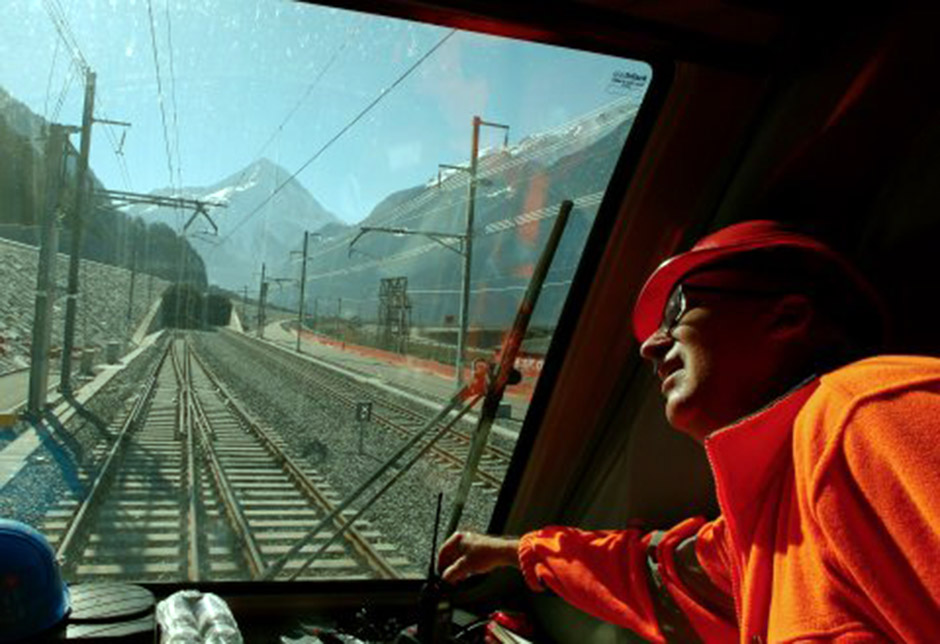 A railway worker looks out of the window of the drivers cabin of a test train in front of the nortern gate of the NEAT Gotthard Base Tunnel during a media visit, near the town of Erstfeld, Switzerland March 10, 2016.