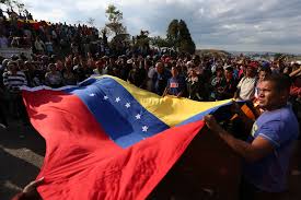 Venezuelanos seguram bandeira do país durante manifestação de apoio ao governo de Nicolás Maduro na fronteira com o Brasil, em Pacaraima, em Roraima 24/02/2019 REUTERS/Bruno Kelly