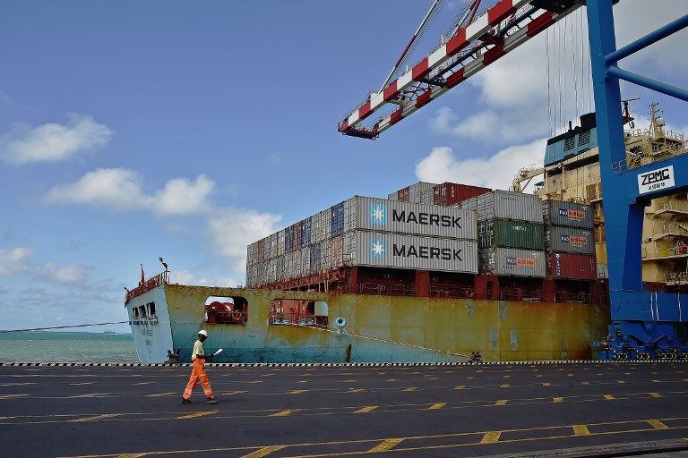 A docker passes by  a container ship on May 5, 2015 in the Doraleh harbour in Djibouti.   AFP PHOTO / CARL DE SOUZA (Photo by CARL DE SOUZA / AFP)